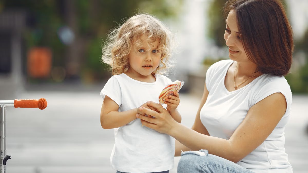 A mother and young daughter share a moment in an urban setting, highlighting family bonding.